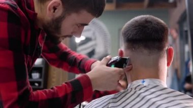 Profesyonel bir berber, müşteri için mükemmel bir saç kesimi yapar.