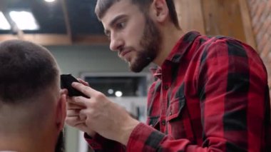 Berber dükkanındaki erkekler için yüksek kaliteli kuaförlük hizmeti. Dikey video