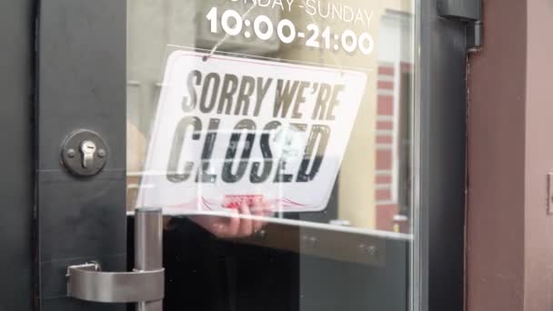 A barbearia abre. O empregado vira a placa e muda a inscrição para Abrir — Vídeo de Stock