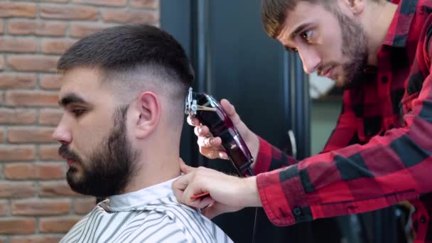 理发师在顾客的后脑勺上理发。黑头发的年轻白人男人。近景 — 图库视频影像