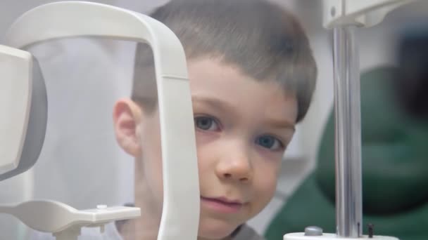 Chlapec na oftalmologické klinice provádí vizuální test na speciálním zařízení — Stock video