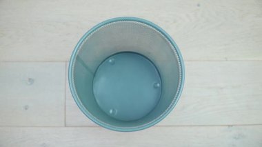 Üç erkek giysisi parçası çöpe düşer. Atık ayıklama ve işleme. Çöp ayıklama. Geri dönüşüm. Boş bir çöp kutusu doluyor.