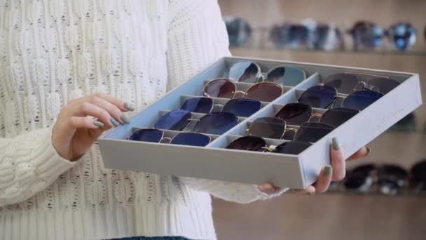 Organisateur avec dix paires de lunettes de soleil dans les mains des femmes — Video