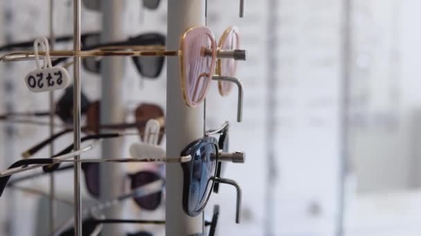 Een breed scala aan verschillende glazen in de winkel of oogheelkundige kliniek. Zijaanzicht — Stockvideo