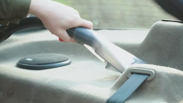 Détail automatique d'une vieille voiture d'occasion. Le panneau avant de la machine est nettoyé avec un aspirateur avec un agent nettoyant. Un homme en vêtements de travail nettoie les sièges avant de la voiture de la poussière et de la saleté. — Video