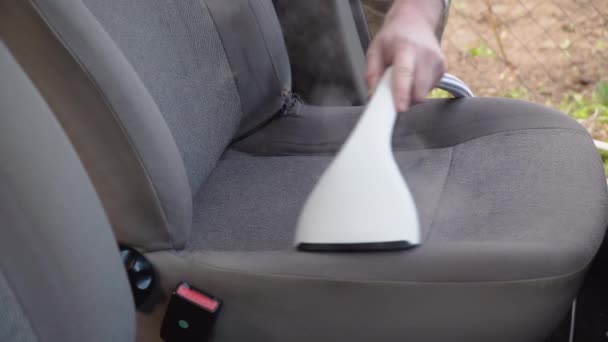 자동차의 오래 된 중고차에 대한 자세 한 정보를 제공 한다. 차의 내부는 증기선 과 함께 청소 된다. 작업복을 입은 남자가 자동차의 앞 좌석을 먼지와 먼지로부터 청소 한다. — 비디오