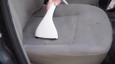 Eski bir arabanın otomatik temizliği. Arabanın içi bir buharlı gemiyle temizlenmiş. İş elbiseli bir adam arabanın ön koltuklarını tozdan ve pislikten temizler..