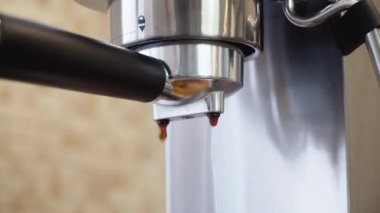 Kahve makinesindeki portatif filtreden köpüklü kahve bir fincana doldurulur.