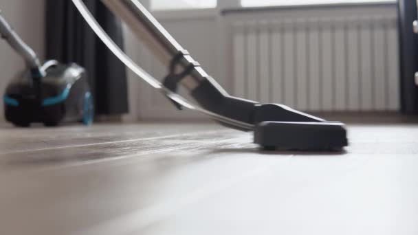 Vacuuming the light oak floor with water. Wet cleaning of housing. Technologies that facilitate cleaning. Modern household appliances — Stock Video