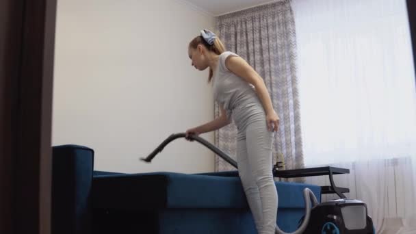 Peralatan rumah tangga modern. vacuum cleaner dengan fungsi cuci. Ibu rumah tangga muda dengan pakaian retro biru muda dengan gaya pin-up — Stok Video