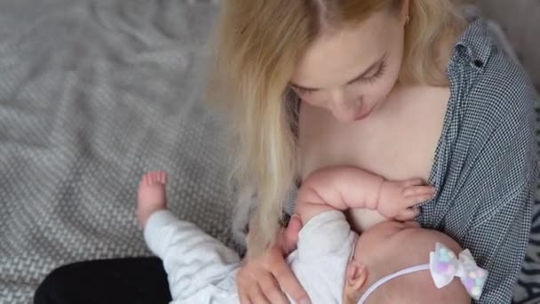 Een moeder geeft haar dochtertje borstvoeding. Bovenaanzicht — Stockvideo