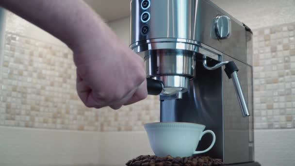 Der Mann montiert den Portafilter in die Kaffeemaschine und schaltet sie ein. Ein Mann kocht Kaffee in einer Kaffeemaschine — Stockvideo