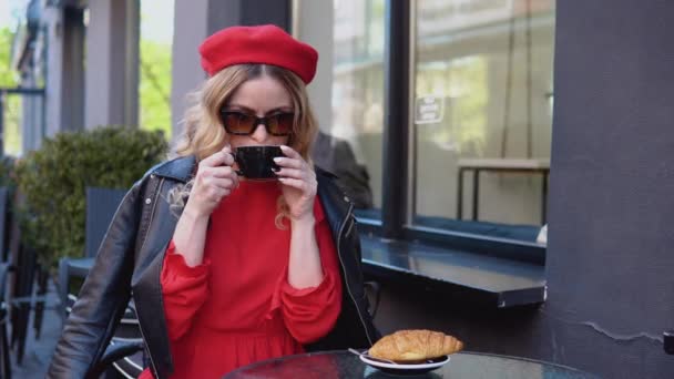 Pomalá ranní estetika. Pařížanka ochutnává kávu a croissant na terase. Přestávka na kávu s croissantem. Životní styl moderní městské mladé ženy — Stock video