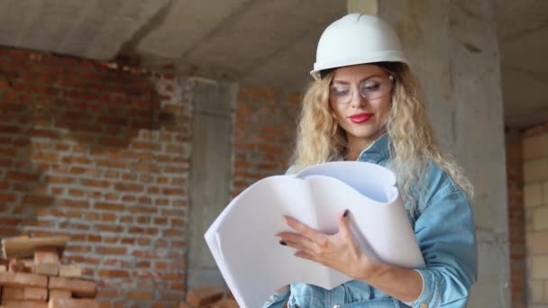 Ev planı. Mimar inşaat sürecini denetliyor. İnşaat alanındaki kadın ustabaşı. — Stok video