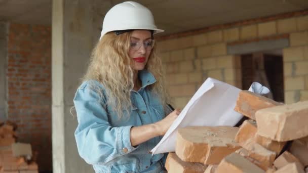 女建筑师阅读了建造这所房子的建筑计划并在其中做了记号 — 图库视频影像