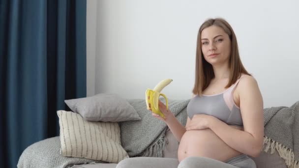 Η έγκυος τρώει μπανάνα και φρούτα. Ισορροπημένη διατροφή και παρακολούθηση βάρους εγκύου. Το ασβέστιο ως απαραίτητο ιχνοστοιχείο για την ανάπτυξη του εμβρύου — Αρχείο Βίντεο