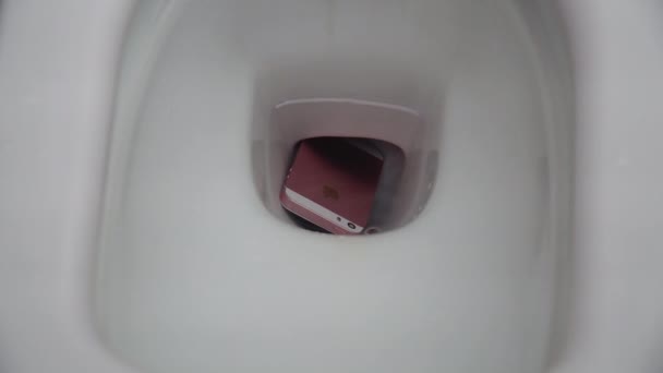 New York, USA - JULY 1, 2021: A man pulls a pink and white smartphone out of the toilet. Breakdown of the smartphone due to contact with water. The water in the toilet drains — Stock Video