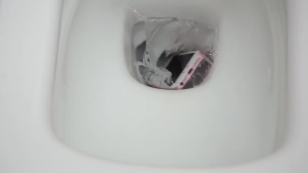 New York, USA - 1er JUILLET 2021 : iPhone rose et blanc tombe dans une toilette blanche avec de l'eau. Panne du smartphone due au contact avec l'eau. Le téléphone portable ne peut pas être réparé — Video