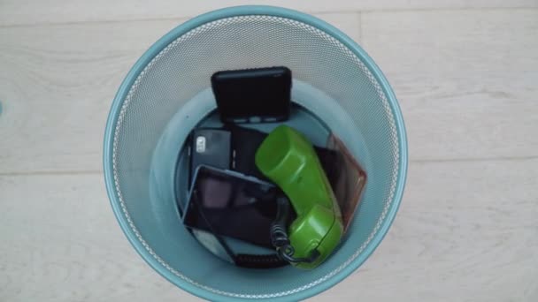 Trash can with mobile phones of different eras revolves around its axis — Stock Video