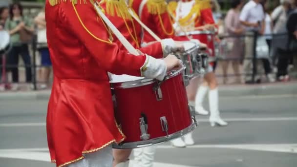 Young girls drummer in red vintage uniform at the parade. Street performance of festive march of drummers girls in red costumes on city street — Stock Video