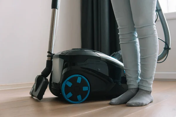 Tecnologías que facilitan la limpieza en húmedo. Electrodomésticos modernos. Mujer de pie junto a una aspiradora con filtro de agua. Tipo de aspiradora y pies —  Fotos de Stock