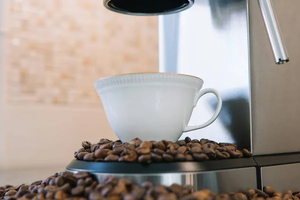 Il processo di versare il caffè da una macchina da caffè in una piccola tazza di porcellana bianca con doratura — Foto Stock