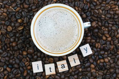 Üstünde İtalya yazan kahve çekirdekleri ve üzerinde kahve olan porselen bir fincan. Kahve üretimi, ihracatı ve ithalatı