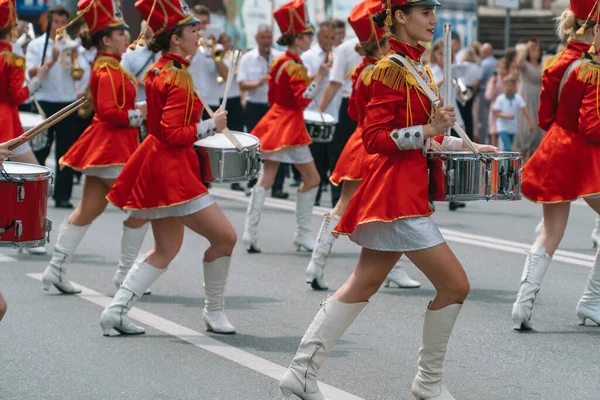 Ternopil, Ukrayna 2 Temmuz 2021: Geçit töreninde kırmızı üniformalı genç kız davulcu. Sokak performansı. Majorette 'lerin geçit töreni