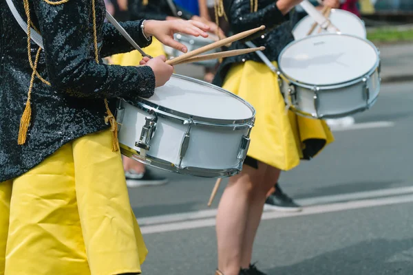 Detailní záběr na ženské bubeníky ve žluté černé retro uniformě na přehlídce. Pouliční představení. Přehlídka joretek — Stock fotografie