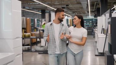 Yeni banyo mobilyalarını seçen ve yeni evleri ya da daireleri için yenileme fikirlerini tartışan mutlu genç bir çift.