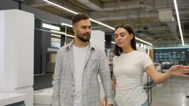 Yeni banyo mobilyalarını, lavaboyu ve aynayı büyük bir hırdavatçıda birlikte seçen mutlu beyaz çift, ev yenileme projelerini tasarlayıp planlıyorlar.