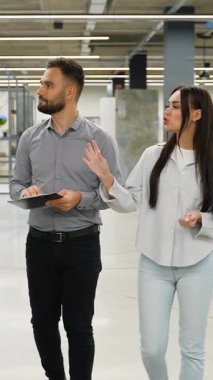 Profesyonel satış asistanı bir hırdavatçıda bayan bir müşteriye danışıyor. Yönetici ve müşteri, yenileme ve tasarım seçeneklerini tartışırken sergi salonunda yürüyorlar.