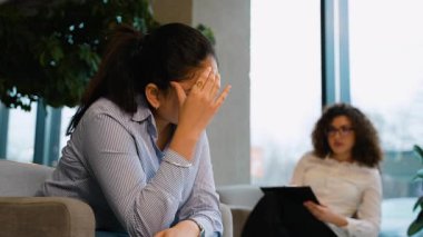 Hüsrana uğramış Hintli kadın sorunlarını bir psikoterapistle paylaşıyor. Psikolog dinlerken hasta ağlıyor ve el kol hareketi yapıyor.
