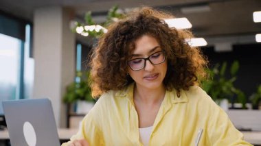 Bir üniversite sınıfında okuyan, ders kitapları okuyan ve konsantrasyon ve motivasyonla sınavlara hazırlanan kendini işine adamış genç bir kadın.