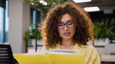 Üniversite sınıfında final sınavlarına hazırlanan genç kız öğrenci, bağımsız olarak öğreniyor ve akademik başarılara odaklanıyor.