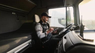 Kendine güvenen erkek sürücü, bir sonraki yolculuğundan önce seyrüsefer ya da rota planlaması için tablet kullanıyor.