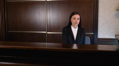 Otel yöneticisi ya da kapıcı olarak çalışan arkadaş canlısı bir kadın ziyaretçileri karşılıyor. Neşeli resepsiyonist mükemmel müşteri hizmetleri sunar.