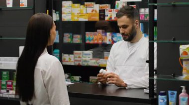 Kadın müşteriye reçeteli ilaç satan profesyonel bir eczacı. Müşteri eczane çıkışında ulaşılamayan bir ödeme için kredi kartı kullanıyor.