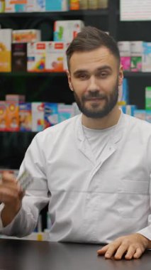 Modern bir eczanenin tezgahında duran yakışıklı bir erkek eczacının portresi.