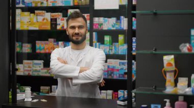 Beyaz önlüklü profesyonel erkek eczacı kameraya bakıyor ve gülümsüyor. Eczanede duran kendinden emin bir eczacı.
