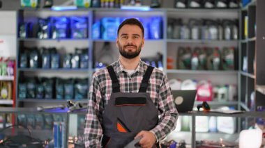 Üniformalı dost canlısı tamirci kaliteli motor yağı öneriyor. Profesyonel satıcı müşteriye kayganlaştırıcı seçmesinde yardım ediyor.