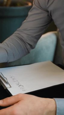 Bir terapistin terapi seansı sırasında hastayı teselli etmesine yakın çekim. Sözcük problemli bir pano görünür