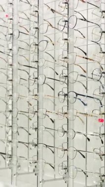 Gözlükçülerin dükkanında gösterilen büyük bir gözlük ve gözlük seçimi. Satılık şık çerçevelerin çeşitliliği