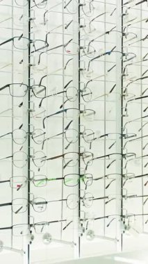 Gözlükçülerin dükkanında bir stantta sergilenen sayısız şık gözlük. Satılık geniş bir görüş düzeltme çerçevesi seçimi