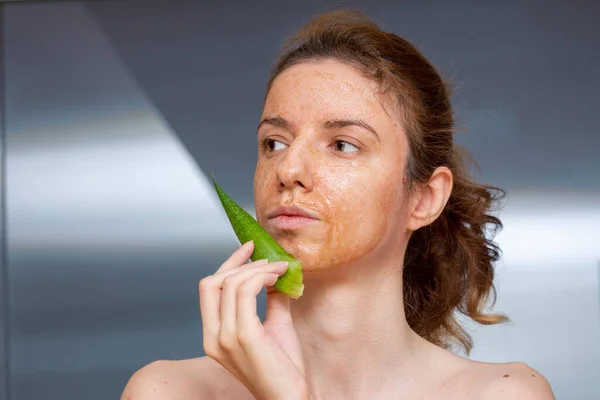 Female model applying and enjoying a diy, homemade mask treatment for dermatitis seborreica made of aloe vera, honey and cinnamon for its anti-inflammatory properties
