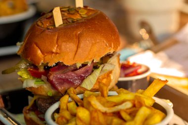 Soğan halkaları, peynir ve sebzeli bir restoranda hamburger yakın çekim.