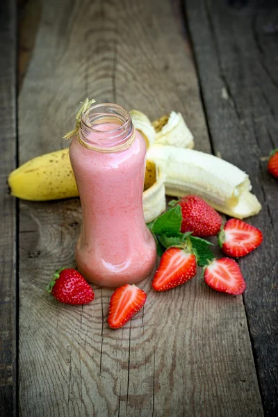 Buatan sendiri strawberry - smoothie pisang dalam guci, minuman menyegarkan dan sehat di atas meja — Stok Foto