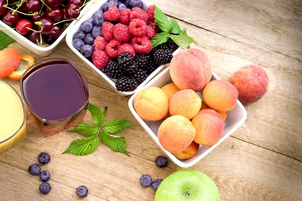 Organic fruits and fresh juices on rustic wooden table — Stock Photo, Image