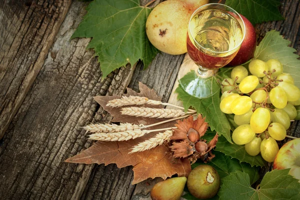 Autumn decoration with wine and organic autumn fruit on rustic table — Stock Photo, Image