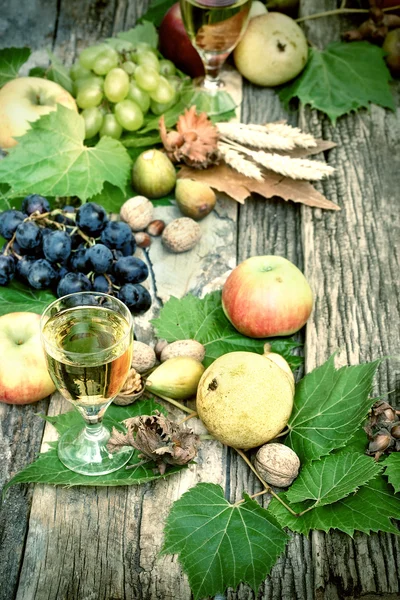 白ワインと素朴な木製のテーブルの上の秋のフルーツ — ストック写真